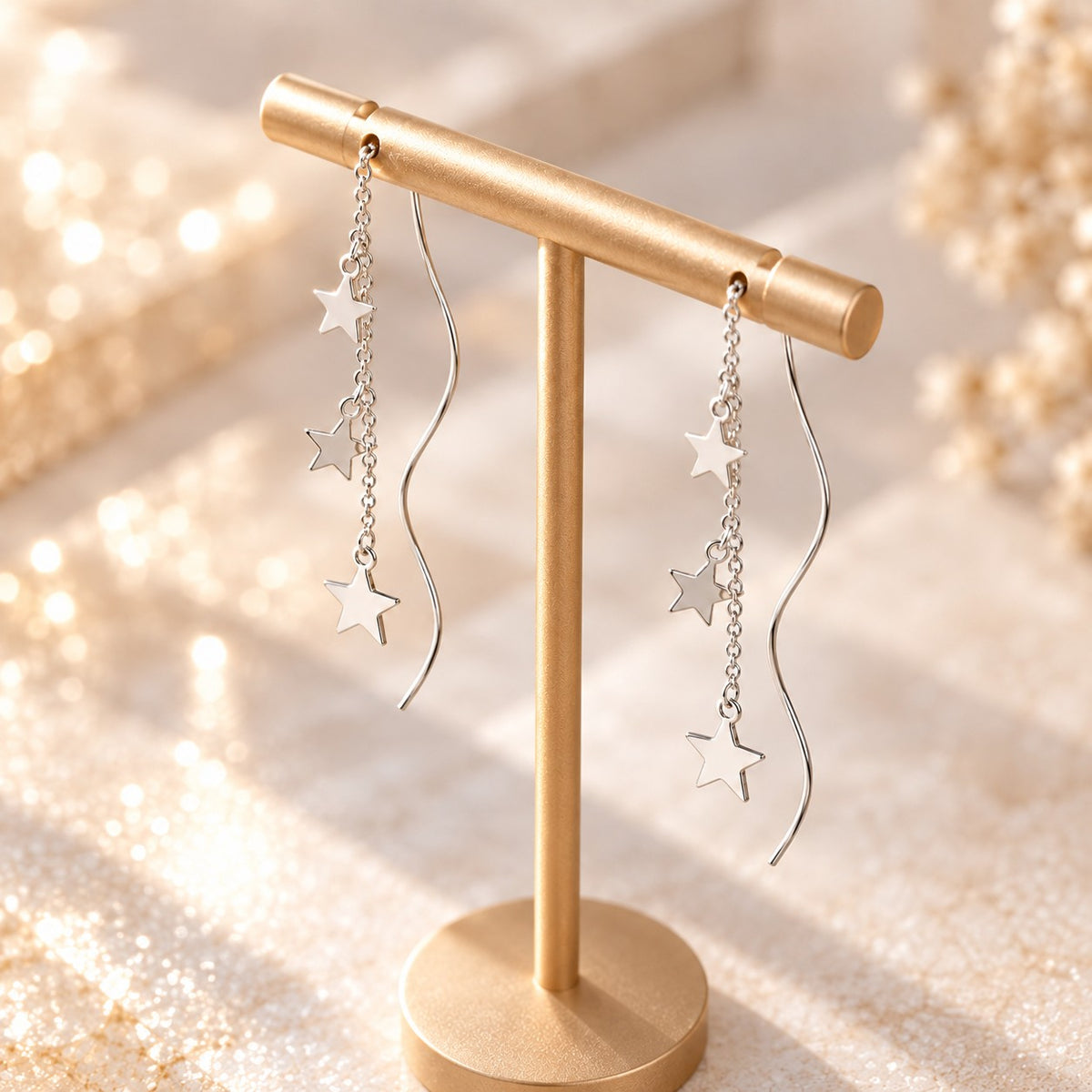 Dainty silver star and wave bar threader earrings on display