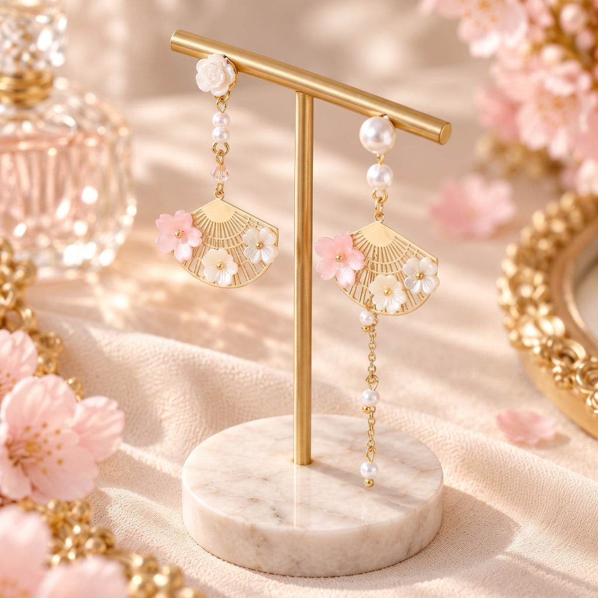 Cherry blossom gold fan pearl earrings on marble display stand