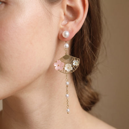Close-up of pearl stud with cherry blossom fan drop on ear