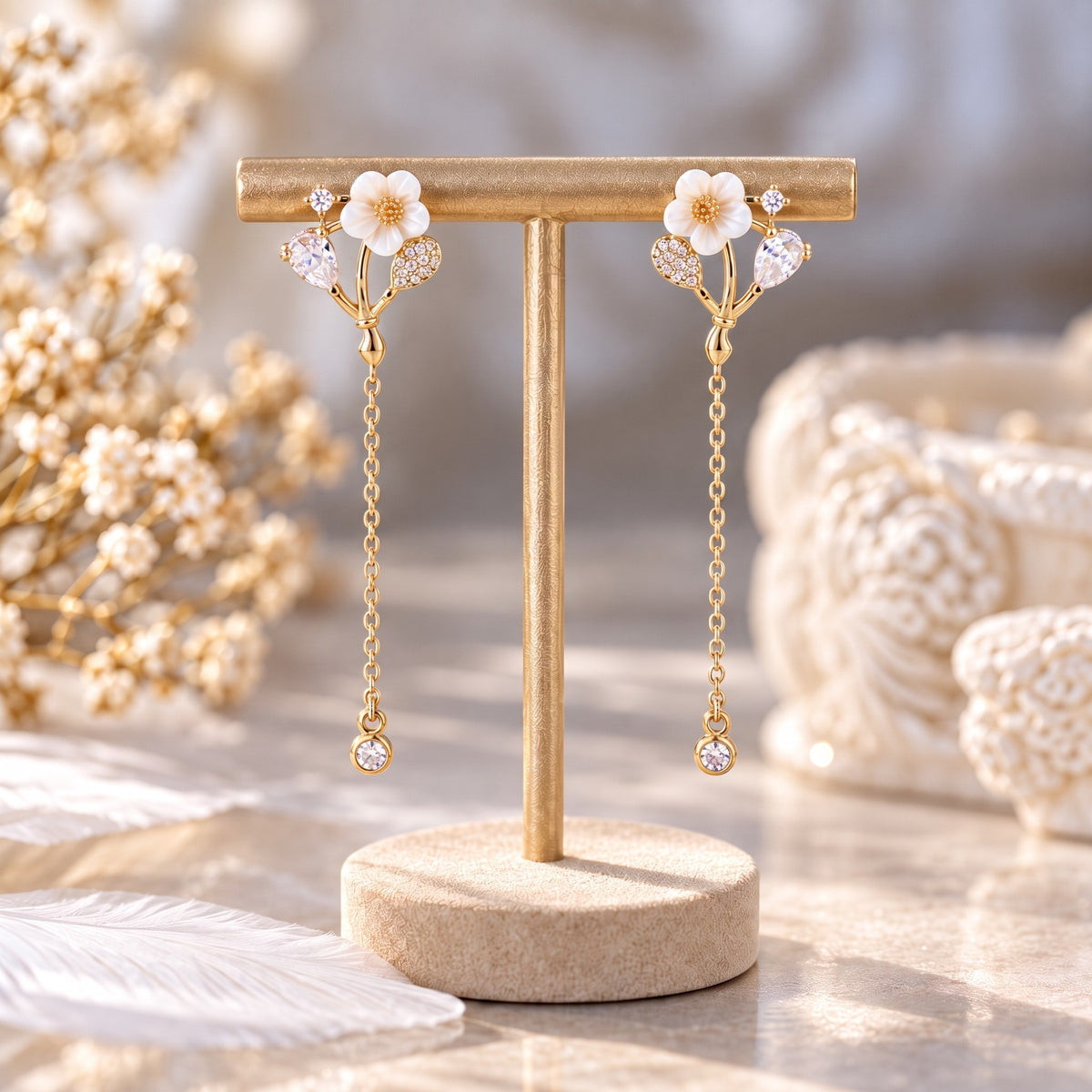 Gold white flower chain drop earrings on gold display stand