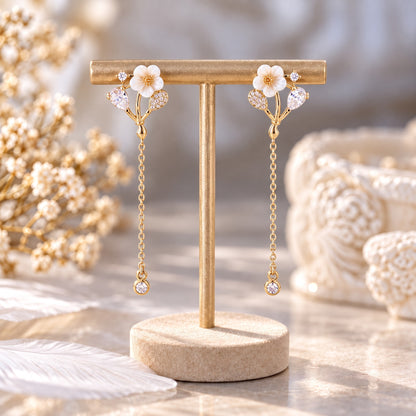 Gold white flower chain drop earrings on gold display stand