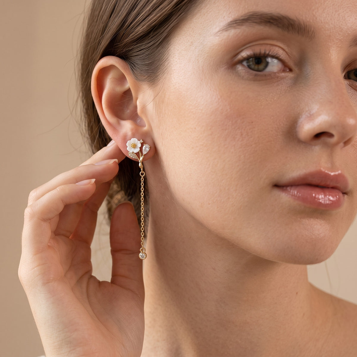 Woman wearing white blossom gold chain drop earring