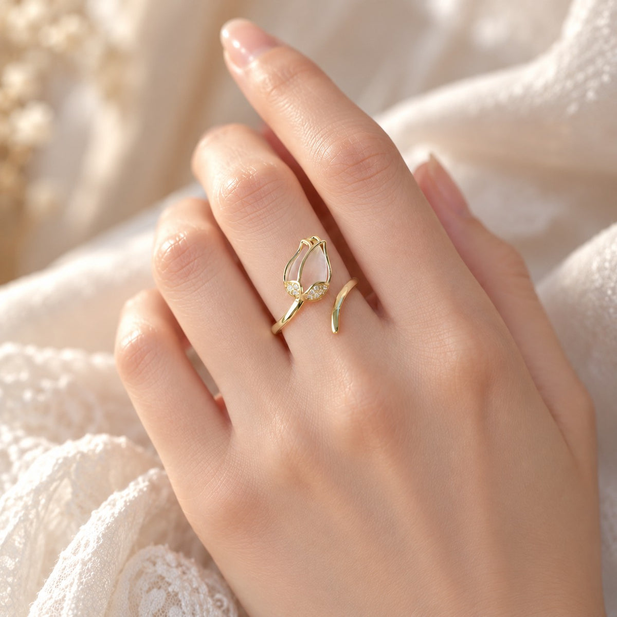 Gold tulip ring worn on finger with lace