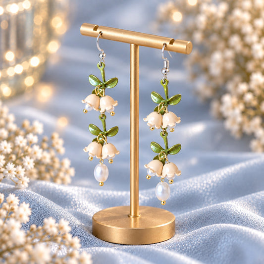 Lily of the valley pearl drop earrings on gold display stand