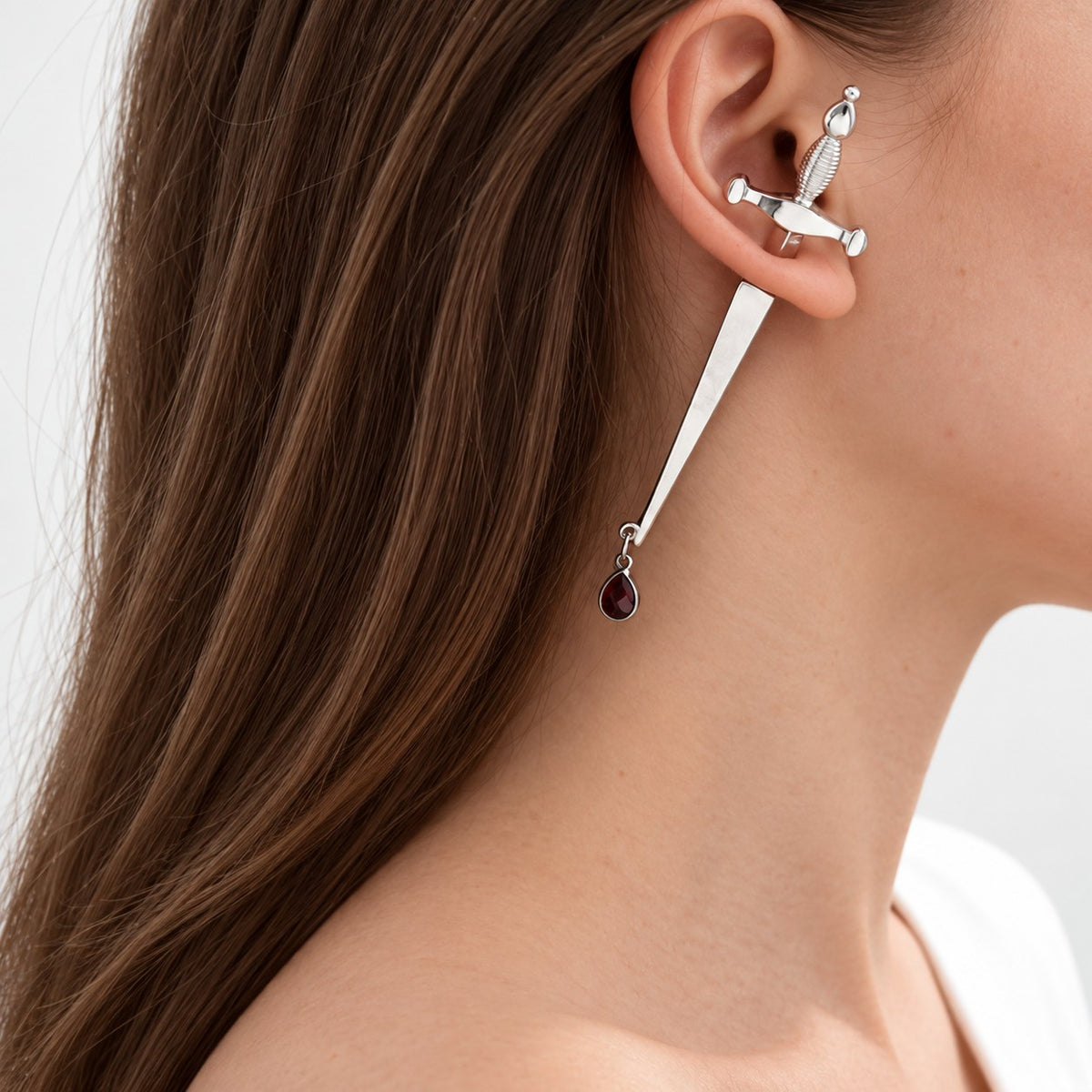 Woman wearing gothic silver sword drop earring