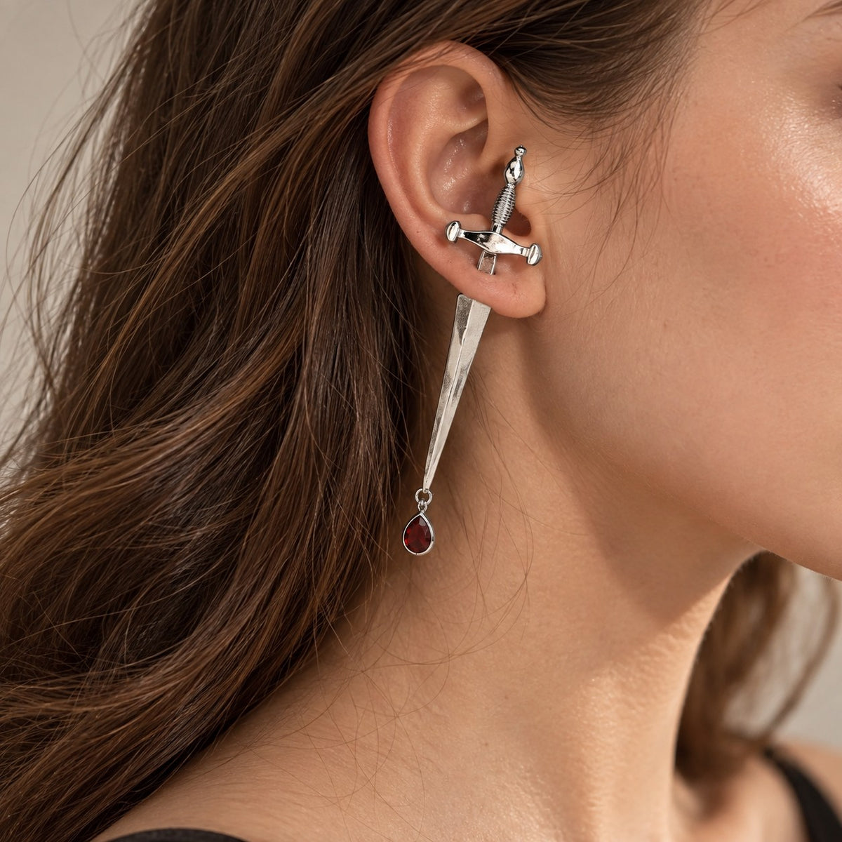 Side view of model wearing silver dagger earring