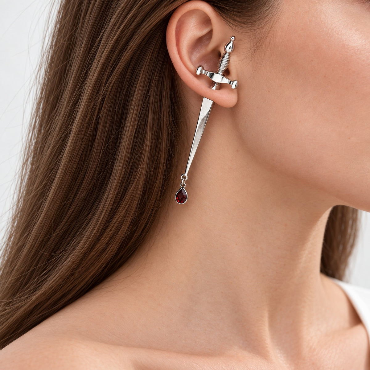 Model wearing gothic sword earring with red crystal