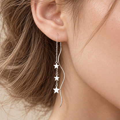 Close-up of silver star threader earring worn on ear