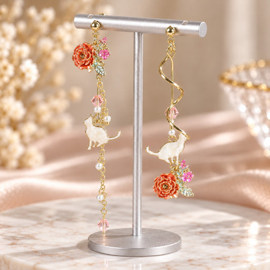 White cat mismatched earrings with coral rose flowers, pearls and gold spiral on an earring stand